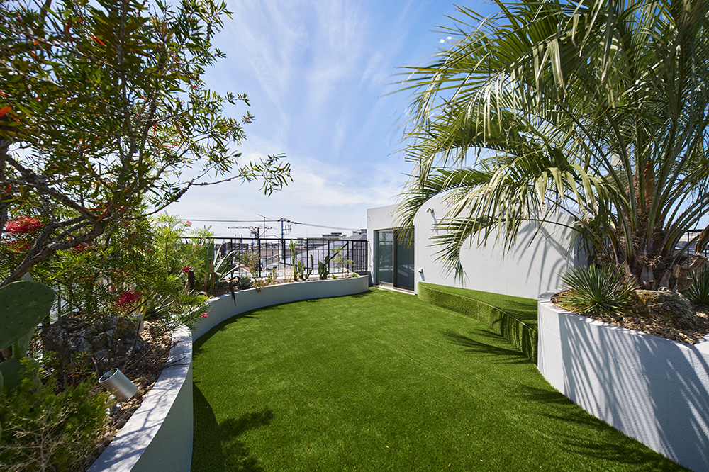 屋上はデザイナーに依頼して南国風の庭に。ＲＣで造作したベンチもあります。