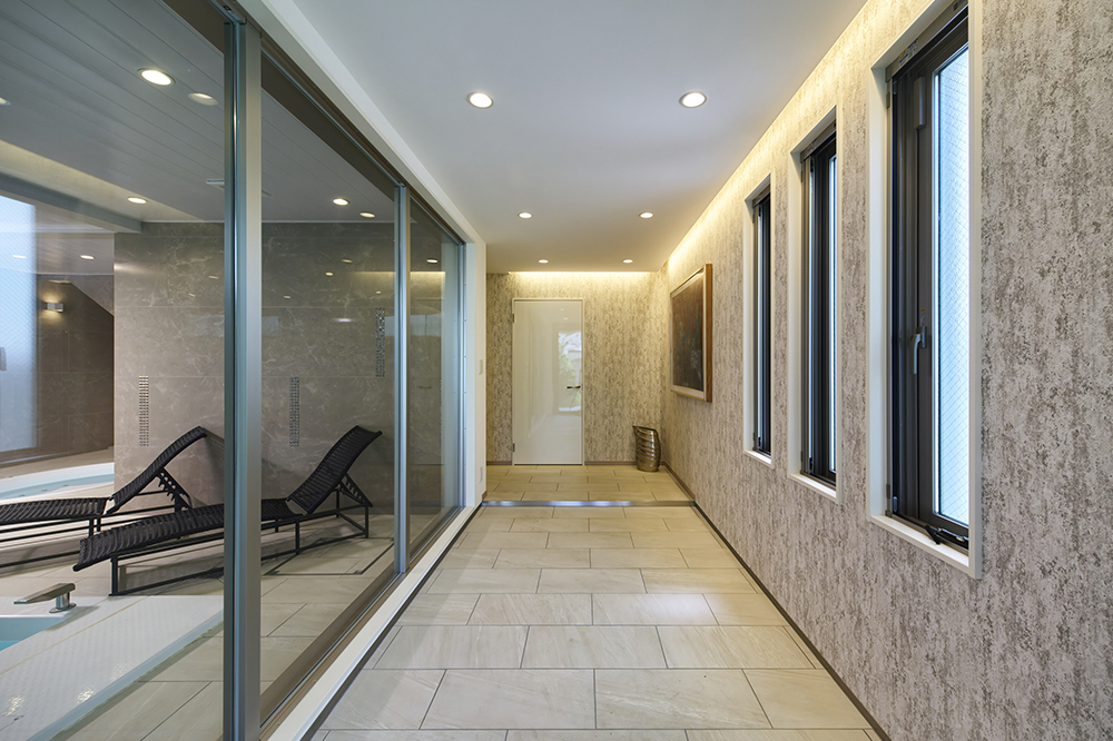 玄関を入るとプールをガラス越しに眺めながら廊下が続きます。