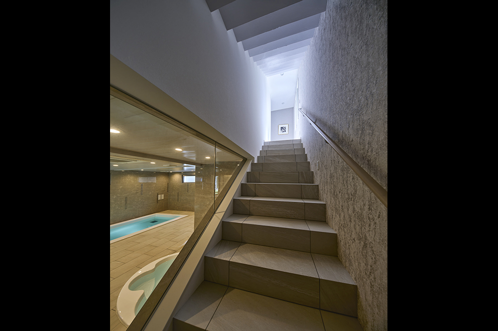 2階への階段もプールを眺めながら。水のある景色が心のゆとりをもたらします。