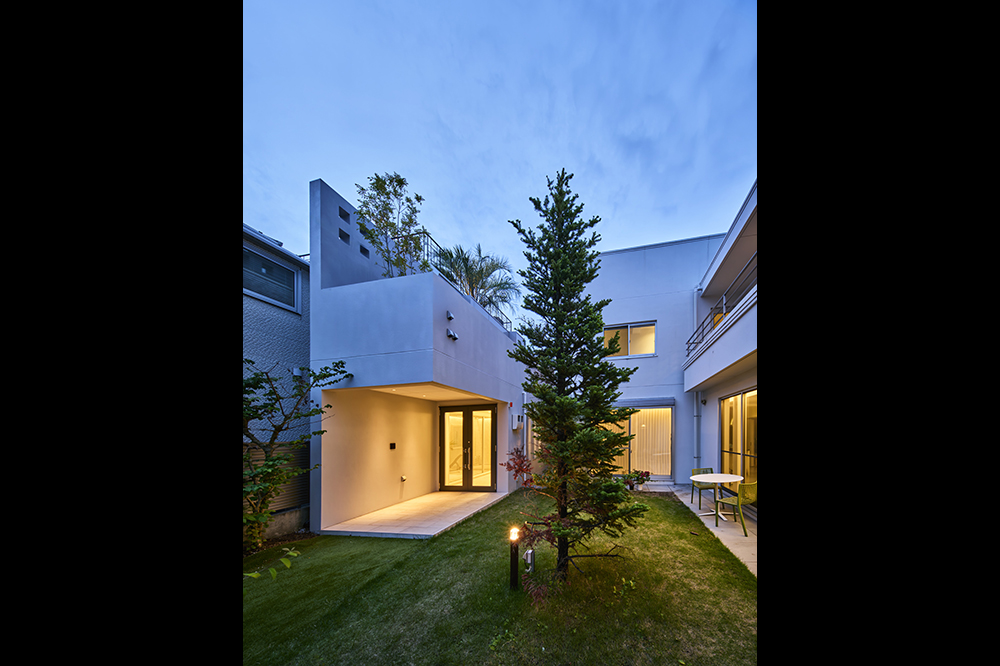 庭の緑に映える白いコンクリートの建物。爽やかな印象です。