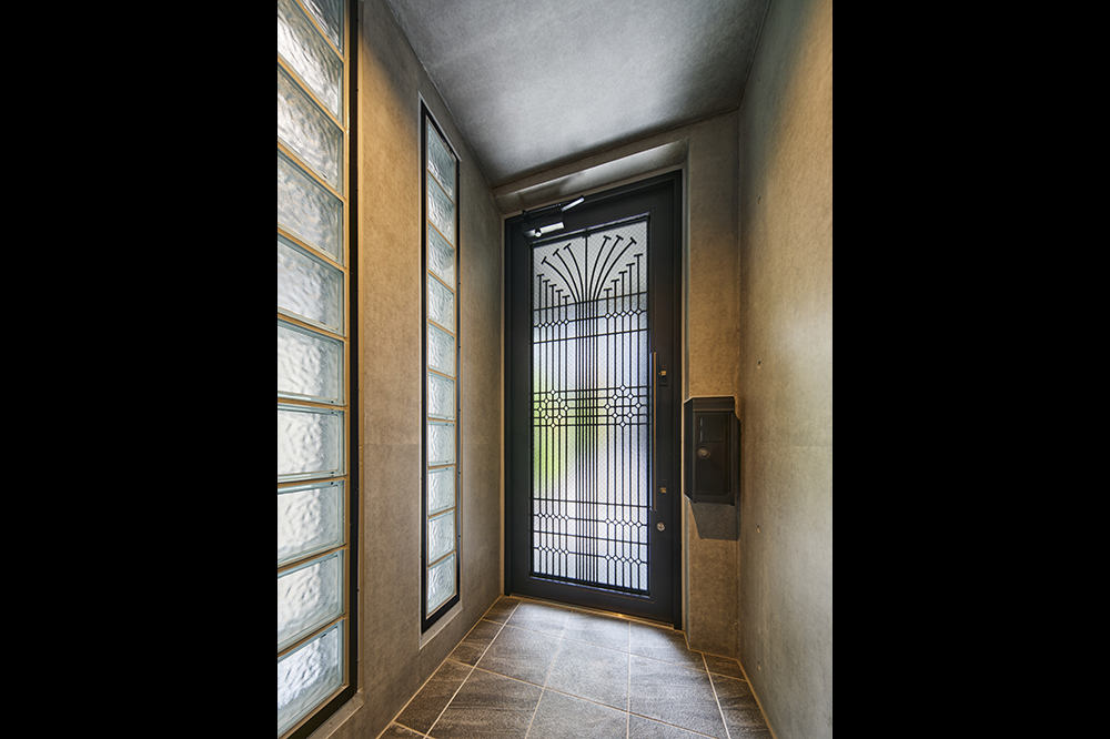 門扉から玄関へのアプローチ。各階とも視線を遮りながら光を取り入れるガラスブロックを多用しました。